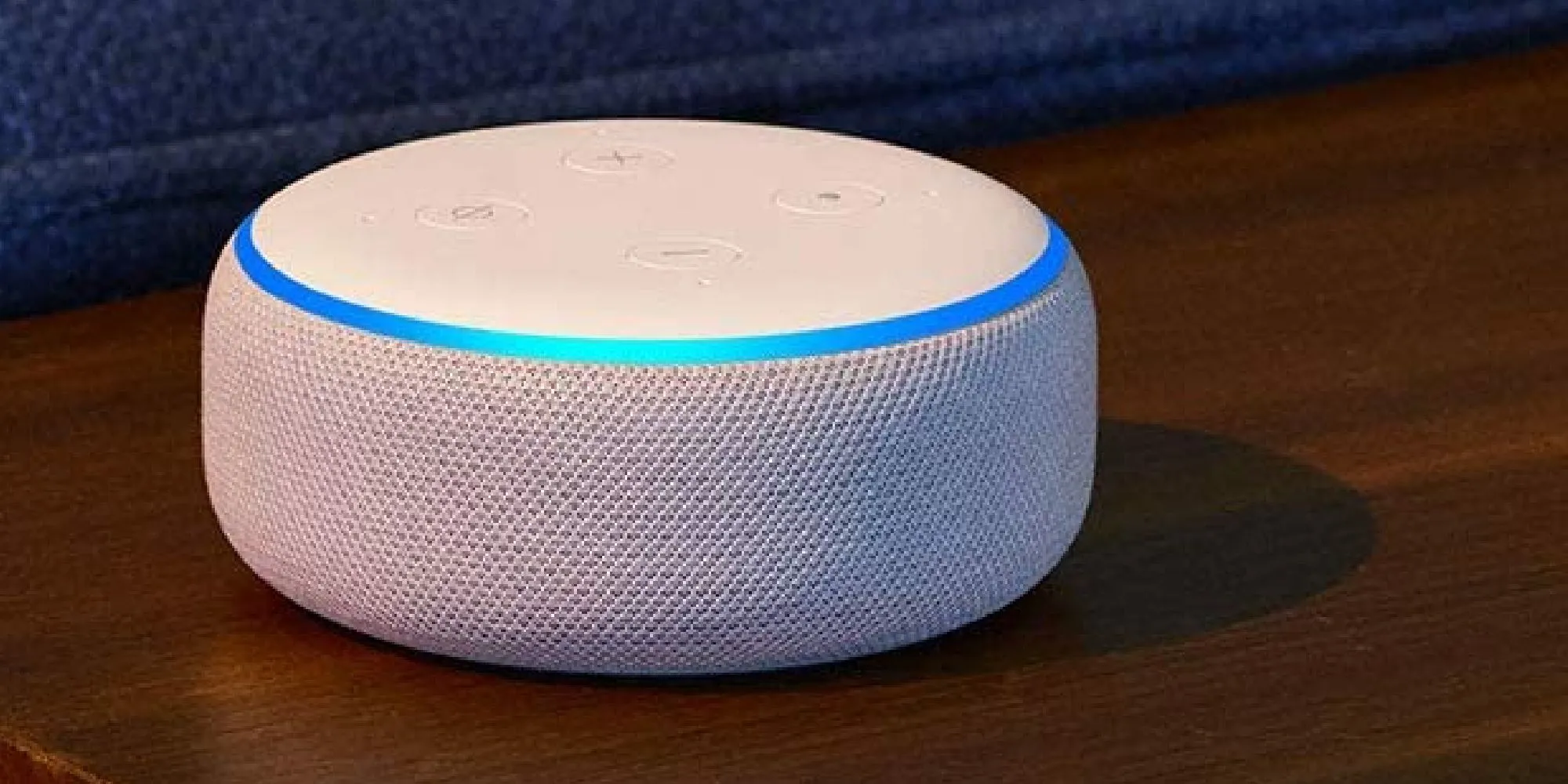 Thiết bị Amazon Alexa màu trắng đặt trên bề mặt gỗ, minh họa ý tưởng loa thông minh dành cho game thủ
