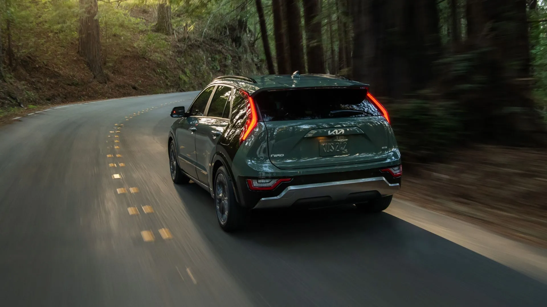 Góc chụp 3/4 phía sau của Kia Niro 2025 trên đường, thể hiện thiết kế thân xe và khí động học