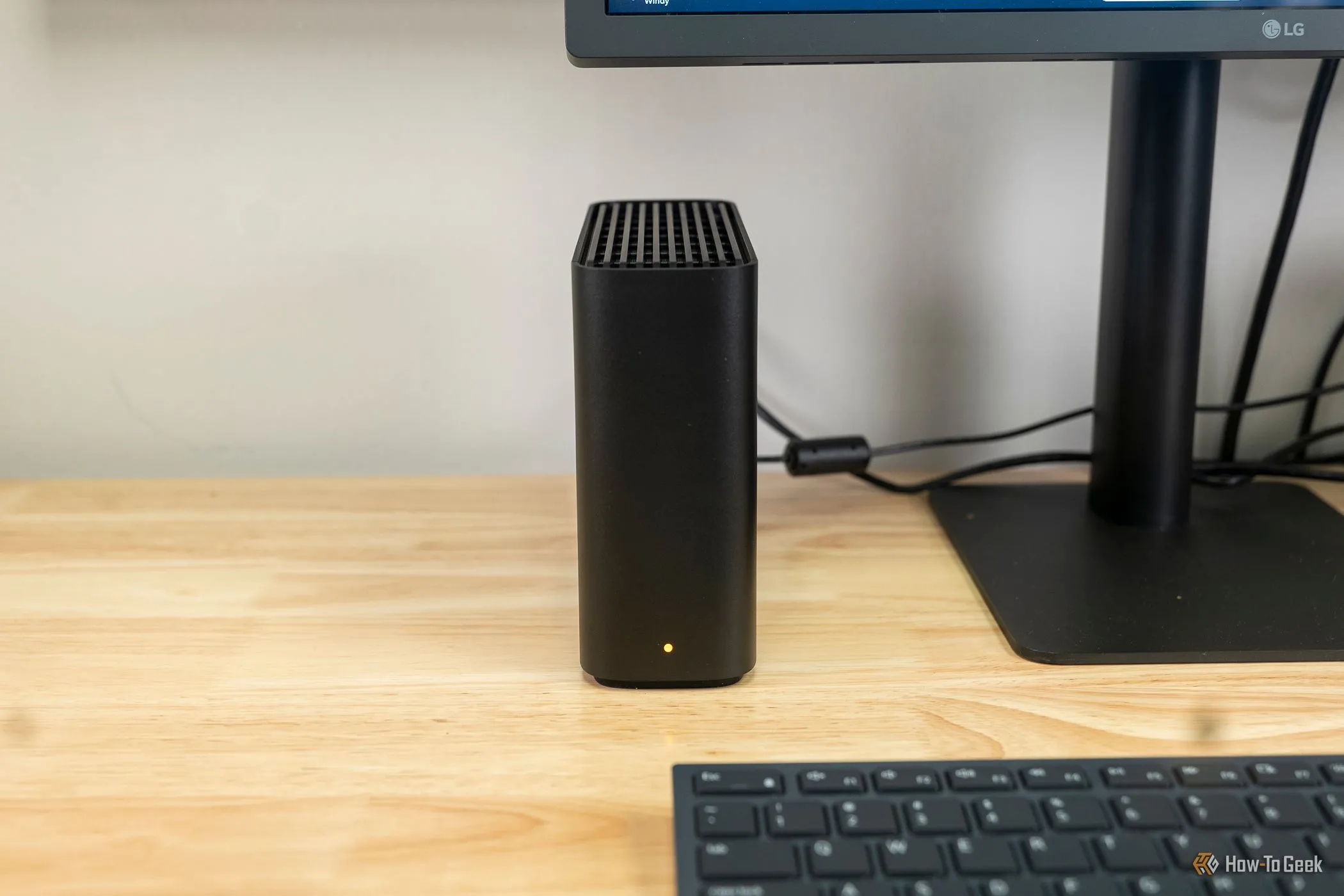 Synology BeeStation đặt cạnh màn hình máy tính, minh họa NAS dùng cho lưu trữ ảnh và file cá nhân