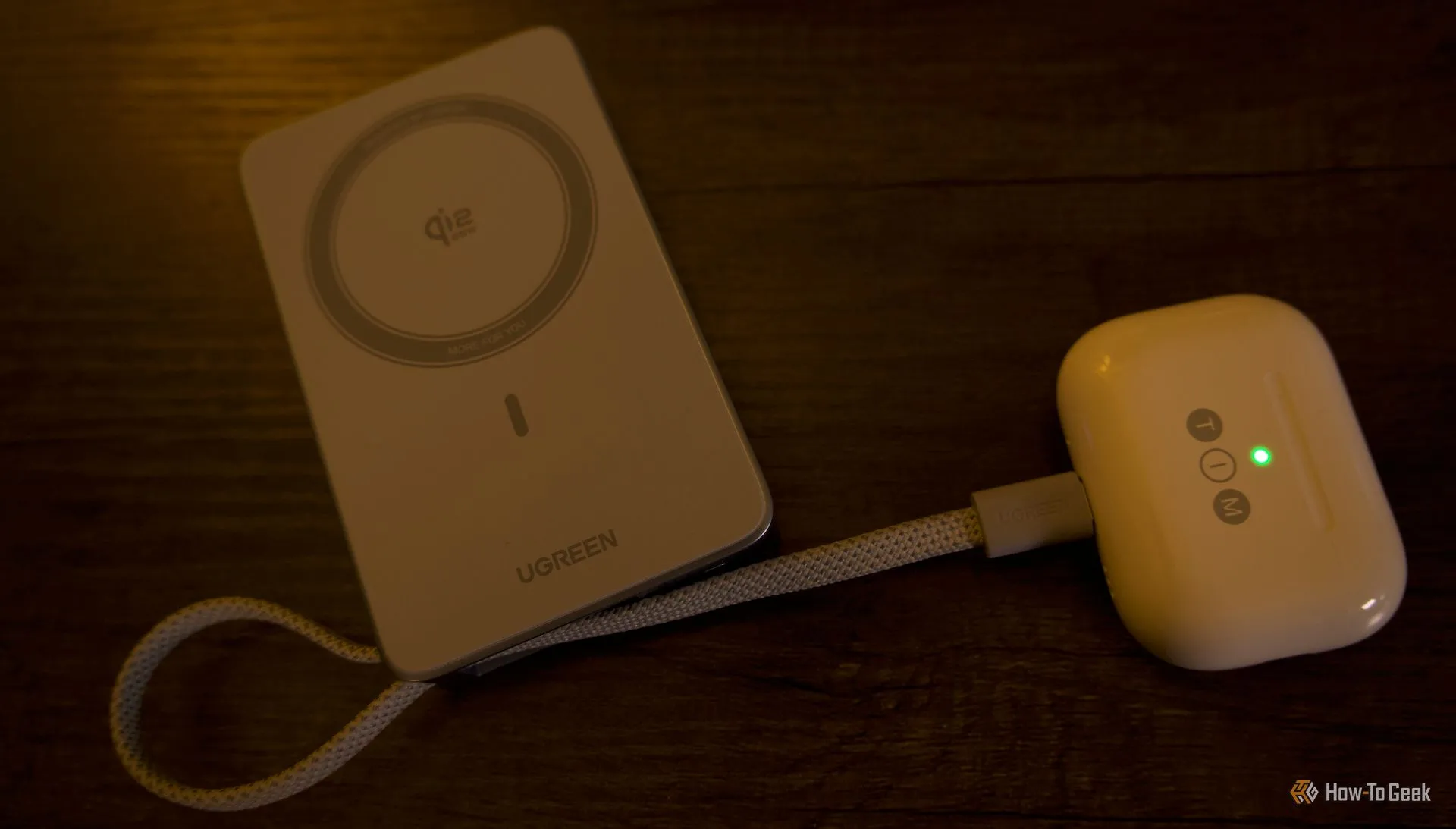 Ugreen MagFlow đang sạc AirPods Pro 3, thể hiện sự tương thích với phụ kiện nhỏ gọn