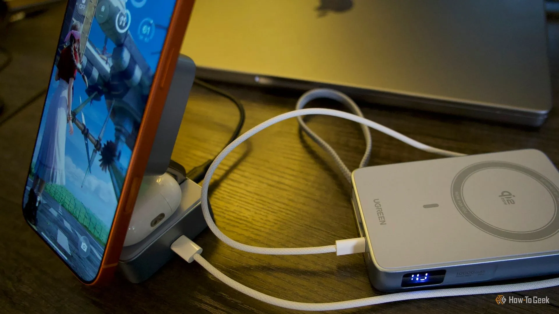 Ugreen MagFlow đang sạc iPhone và AirPods, đồng thời kết nối một powerbank qua cổng USB-C pass-through, thể hiện tính tiện lợi khi du lịch.